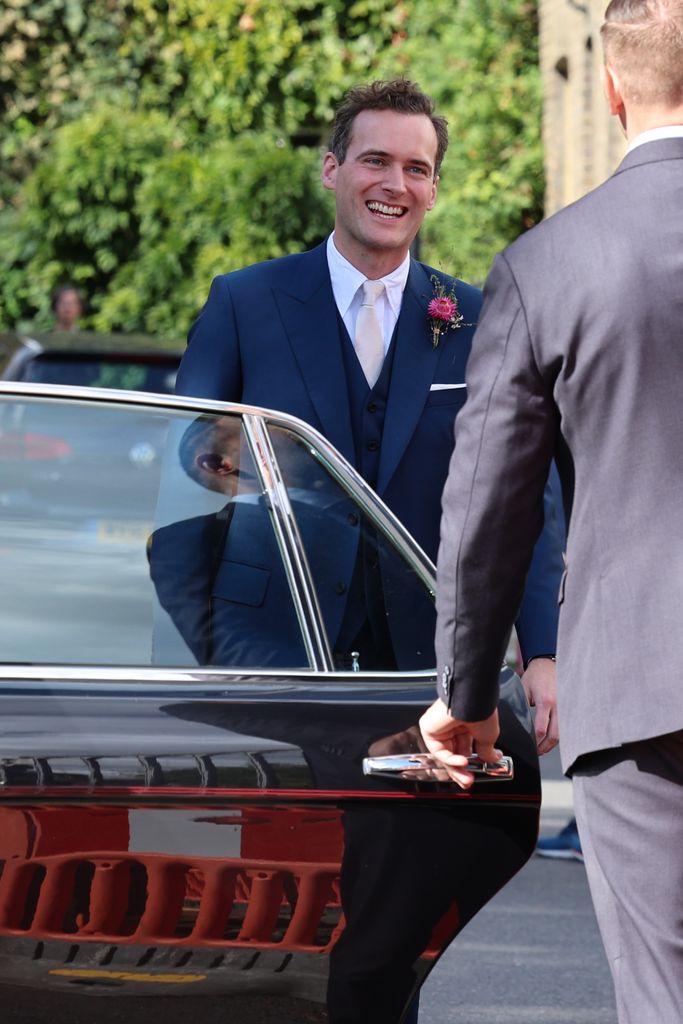The groom, Jasper Waller-Bridge looked suave and smiling in a navy suit