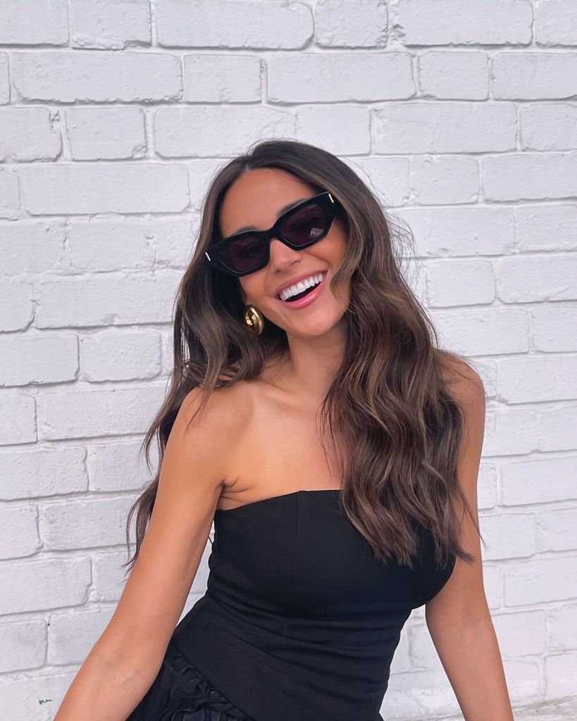 woman smiling in strapless top and sunglasses