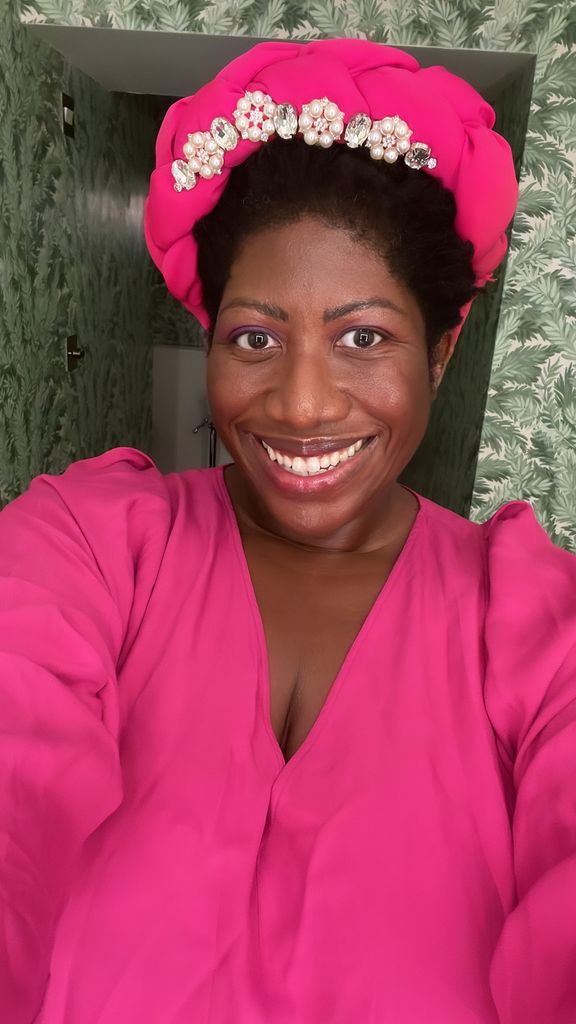 black woman smiling in a pink hat