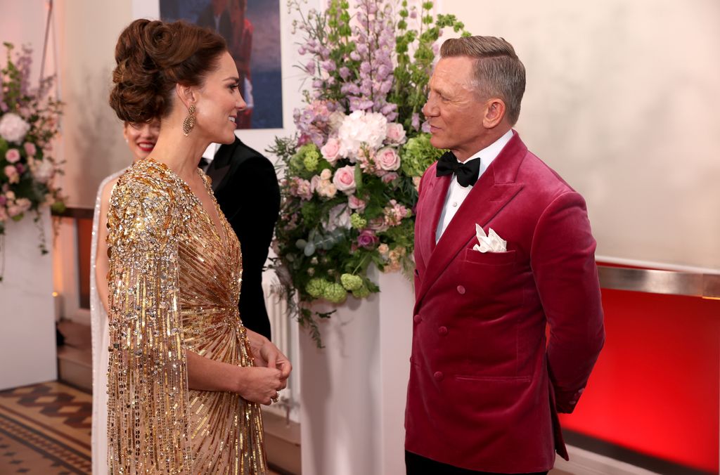 Kate in gold dress talking with daniel craig