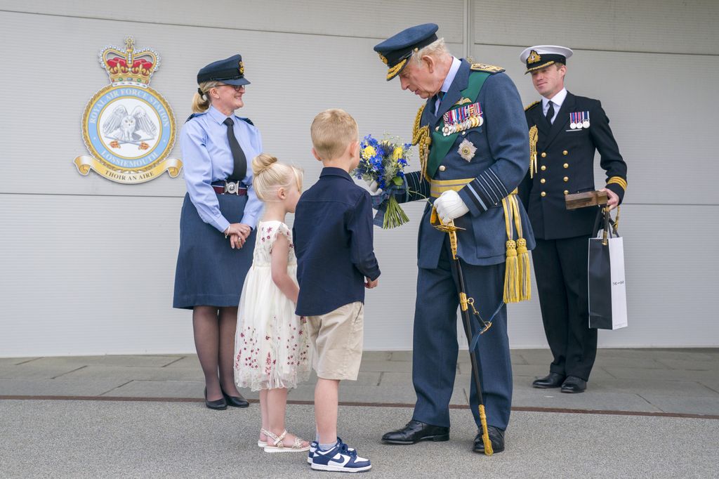 King Charles III is presented with flowers during his visit to RAF Lossiemouth in Moray