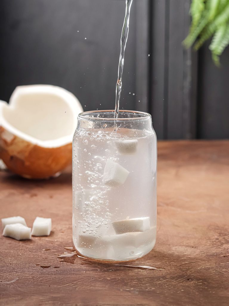 coconut water in a glass. pour coconut water into a glass