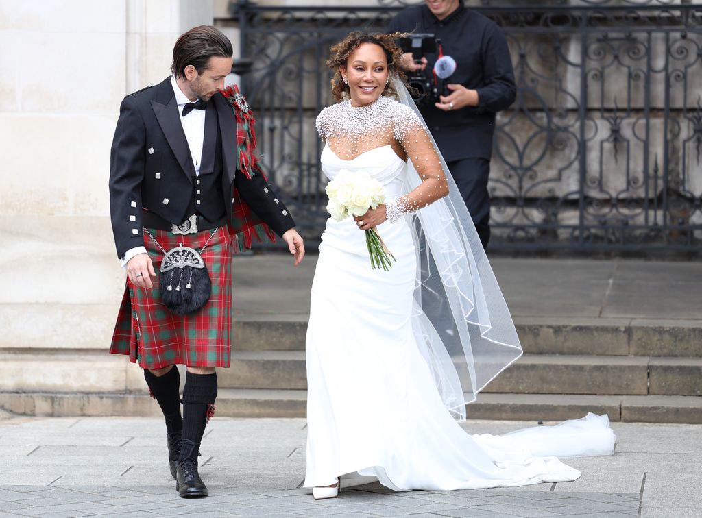 Melanie B in bridal gown beside husband in kilt