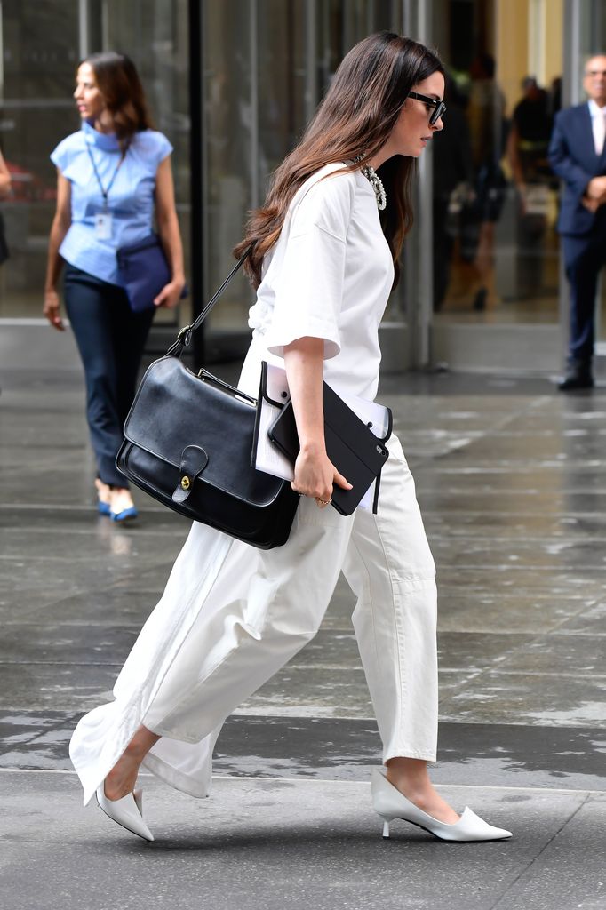 Anne Hathaway carries a vintage Coach Metropolitan satchel wearing white outfit