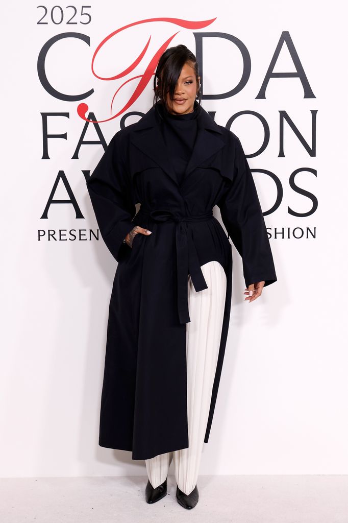 Rihanna attends the 2025 CFDA Awards at American Museum of Natural History in a black coat with white trousers