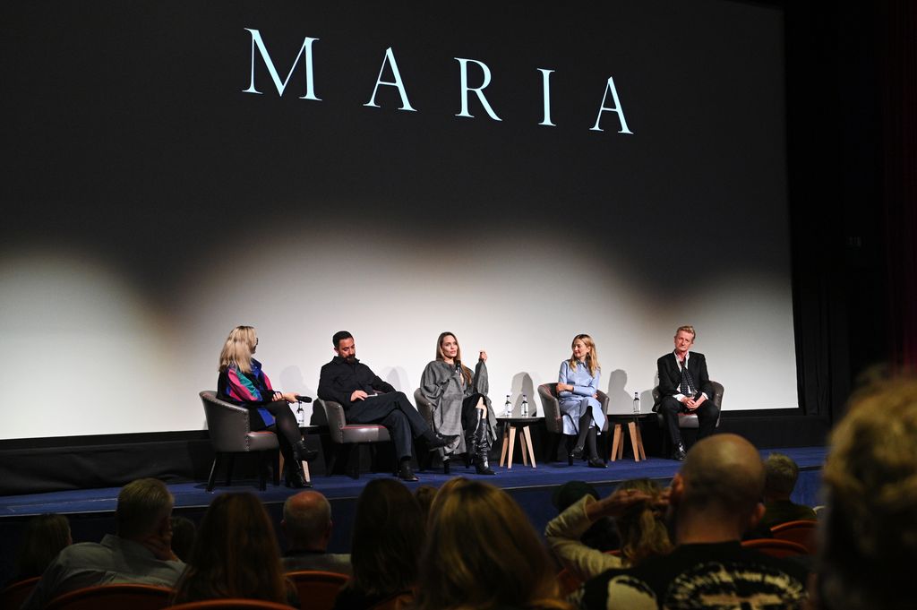 quatro pessoas sentadas no palco durante a exibição do filme