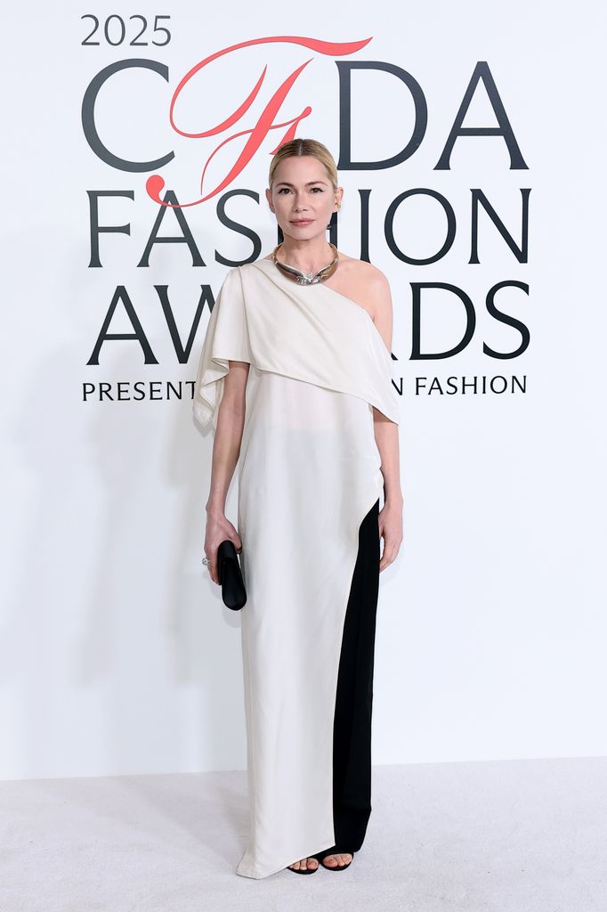 Michelle Williams attends the CFDA Awards in a cream off the shoulder dress with black panel and black accessories.