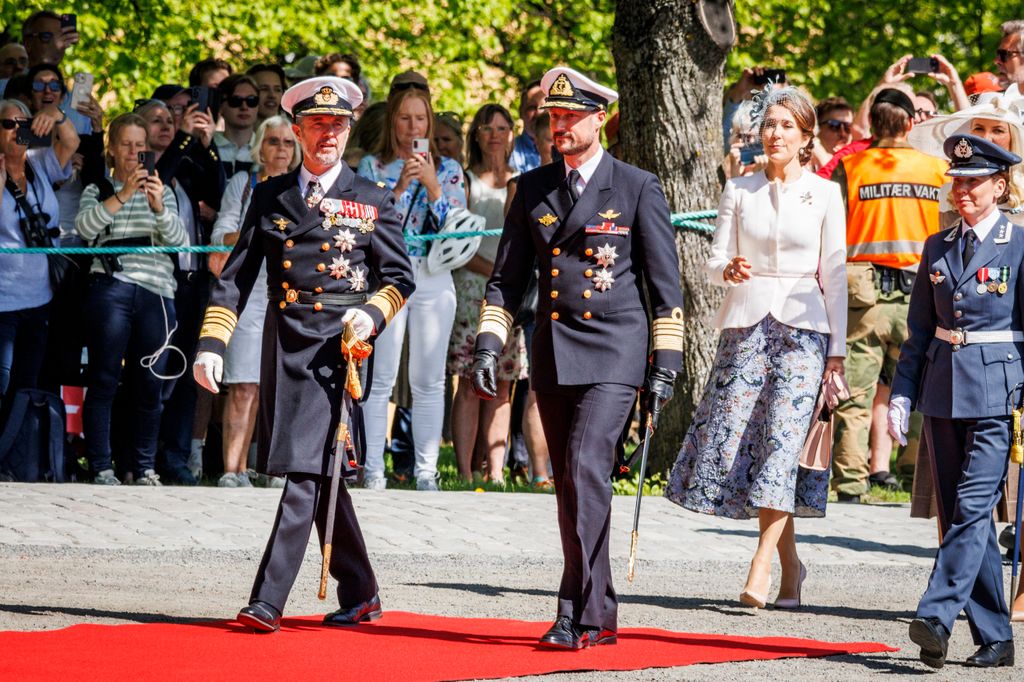 King Frederik walking with Crown Prince Haakon and Queen Mary