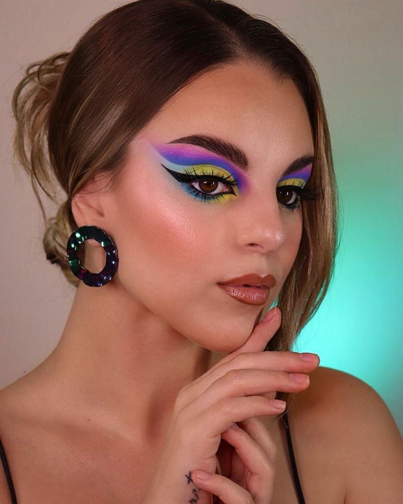 Woman with sharp colourful cut crease makeup 