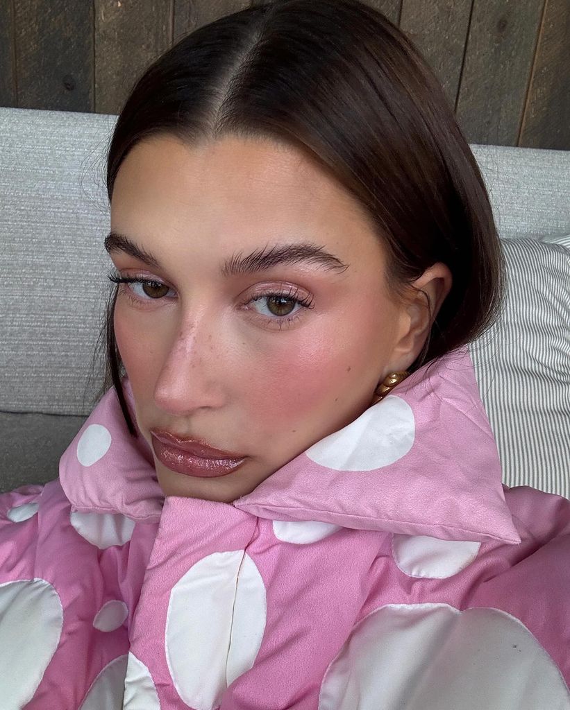 Hailey Bieber looking cosy and pink-cheeked in a polka dot puffer