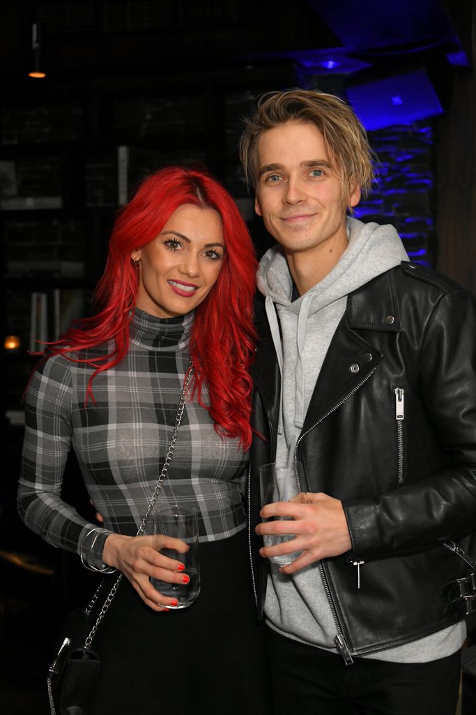 Dianne Buswell e Joe Sugg segurando óculos