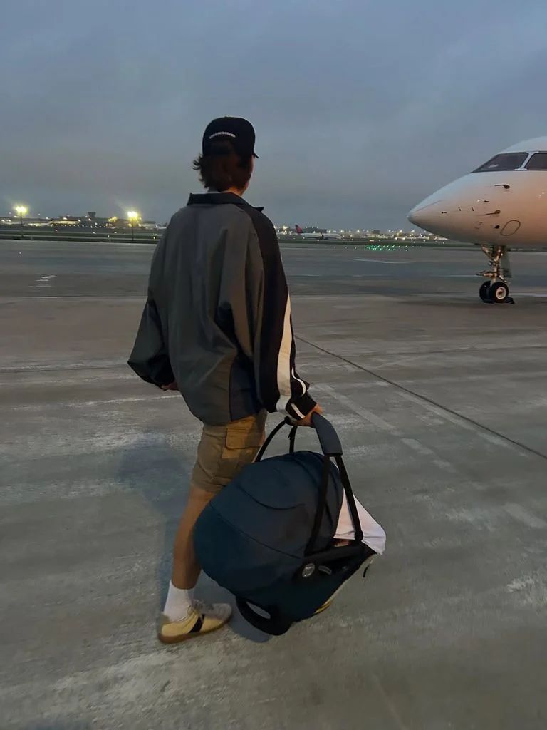 jake bongiovi walking to plane with baby carrier