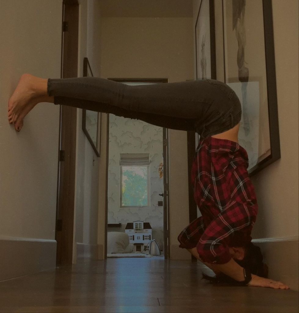 photo of daniela ruah performing headstand against a wall