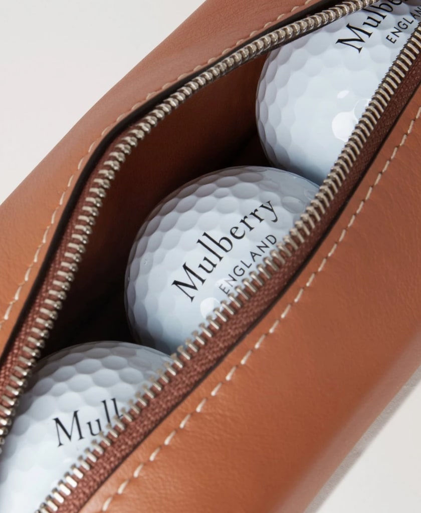 A close up of Mulberry golf balls in a brown leather case 