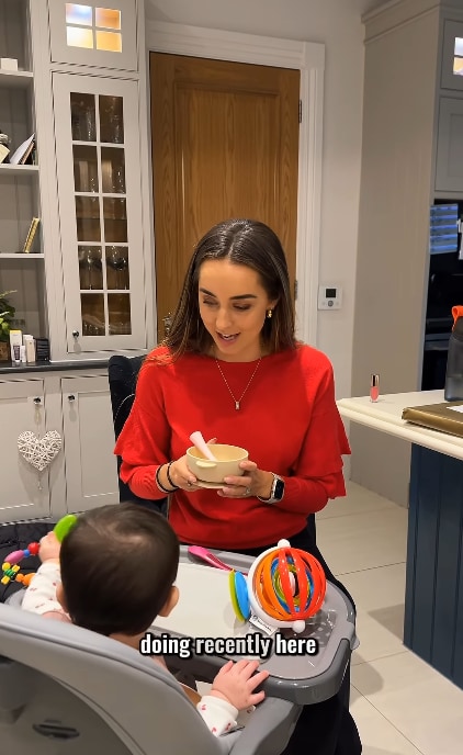 Emily feeding Arabella in high chair