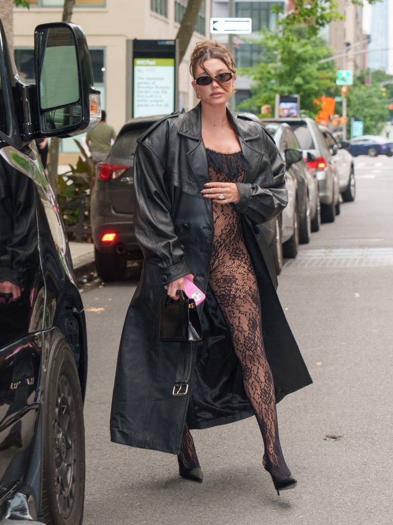 Hailey rocked a risqué lace catsuit, leather trench and heels