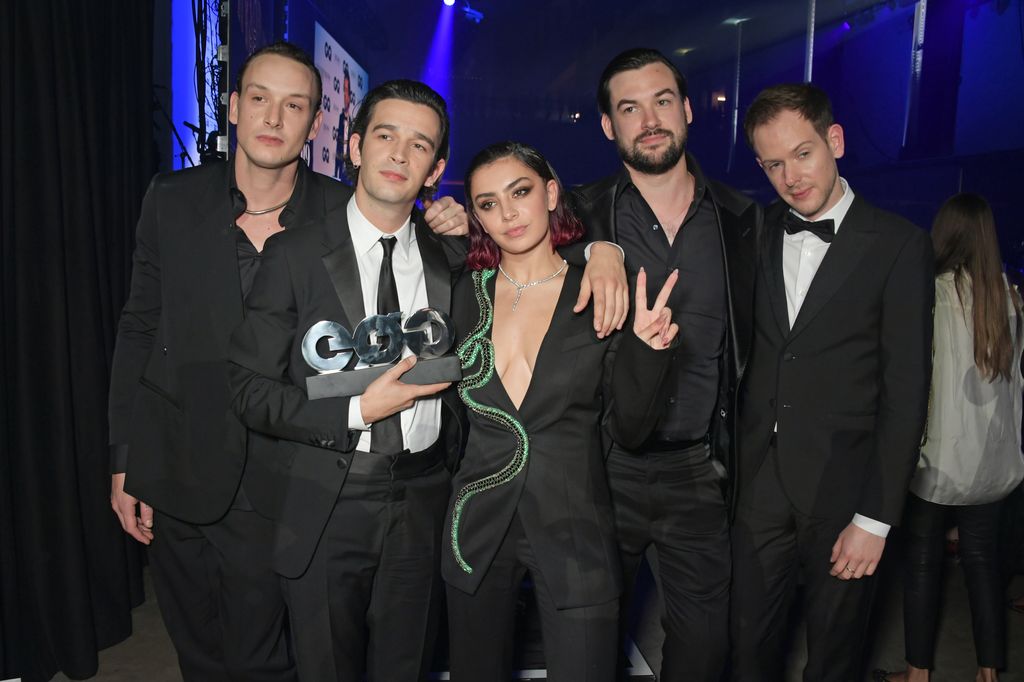 Charli XCX (C) poses with George Daniel, Matthew Healy, Ross MacDonald and Adam Hann of The 1975, winners of the GQ Band of the Year award, at the the GQ Men Of The Year Awards 2019