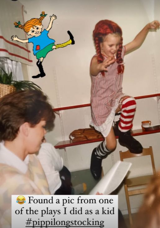 A child in a red wig jumping onto a chair