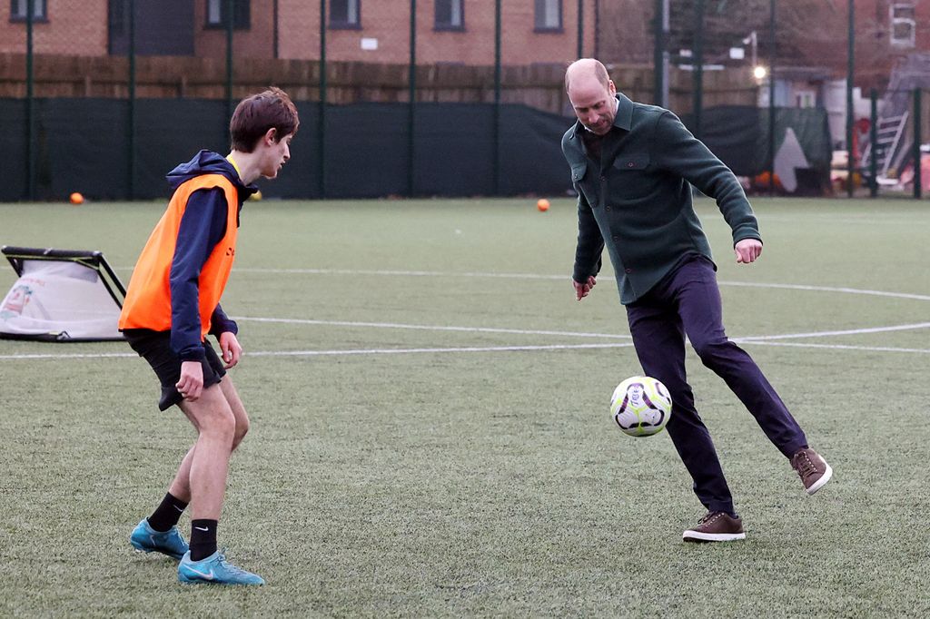 two men kicking football 