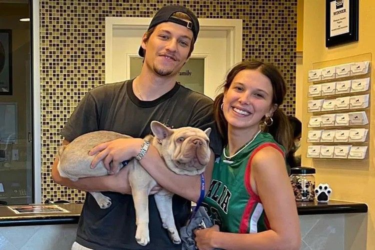 millie bobby brown and jake bongiovi holding a dog