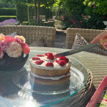 A victoria sponge cake being cut 