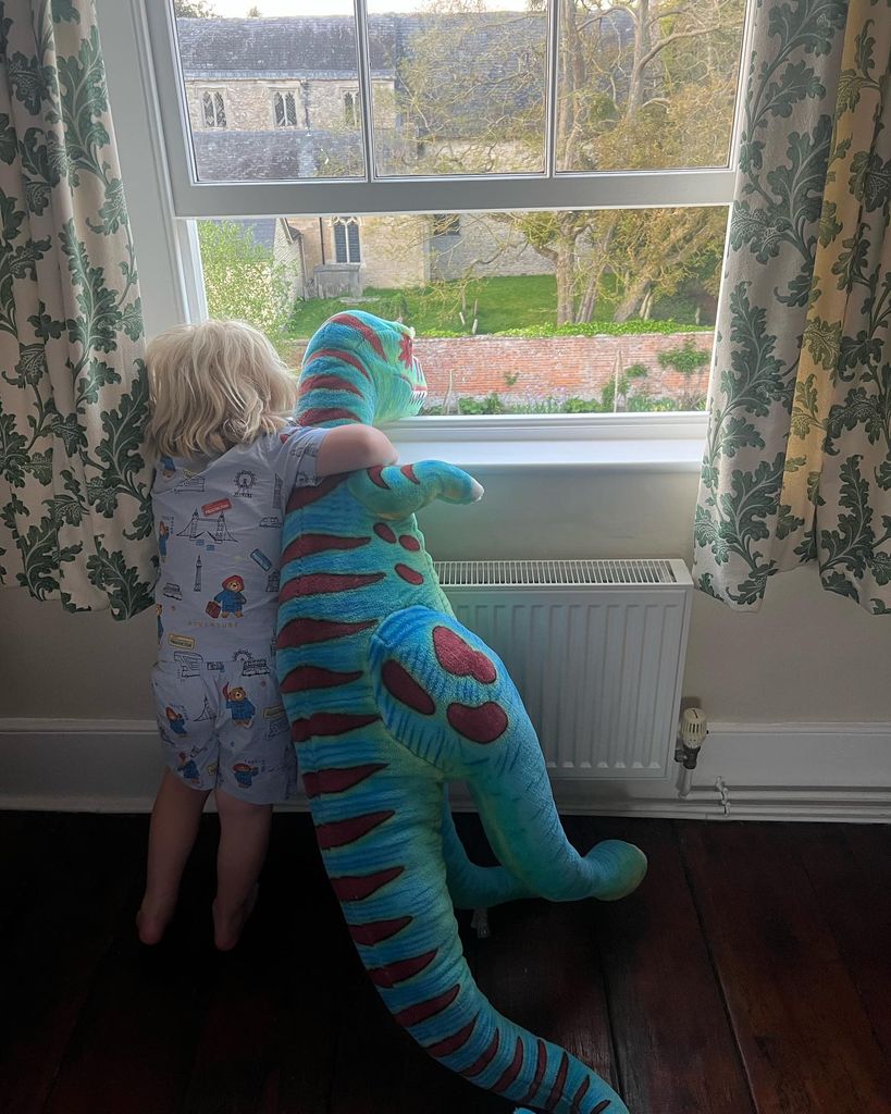 young boy holding toy dinosaur 