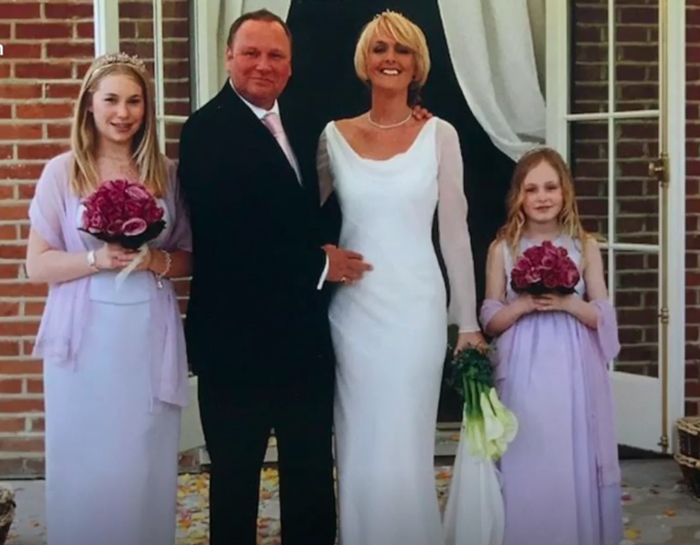 Jane Moore and Gary Farrow standing next to their kids in purple bridesmaid dresses