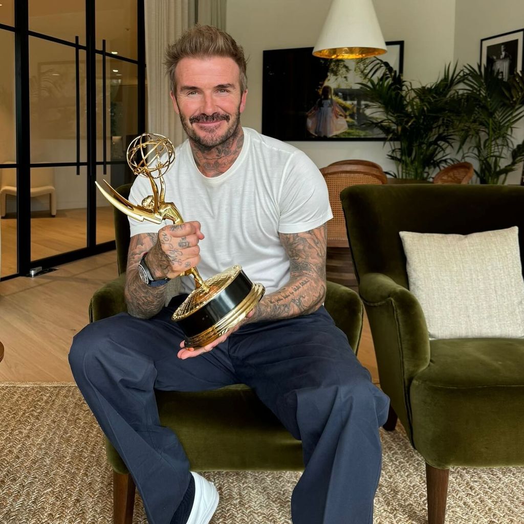 David Beckham posing with his Emmy in his home office