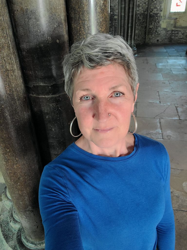 woman taking a selfie in a long-sleeved blue top