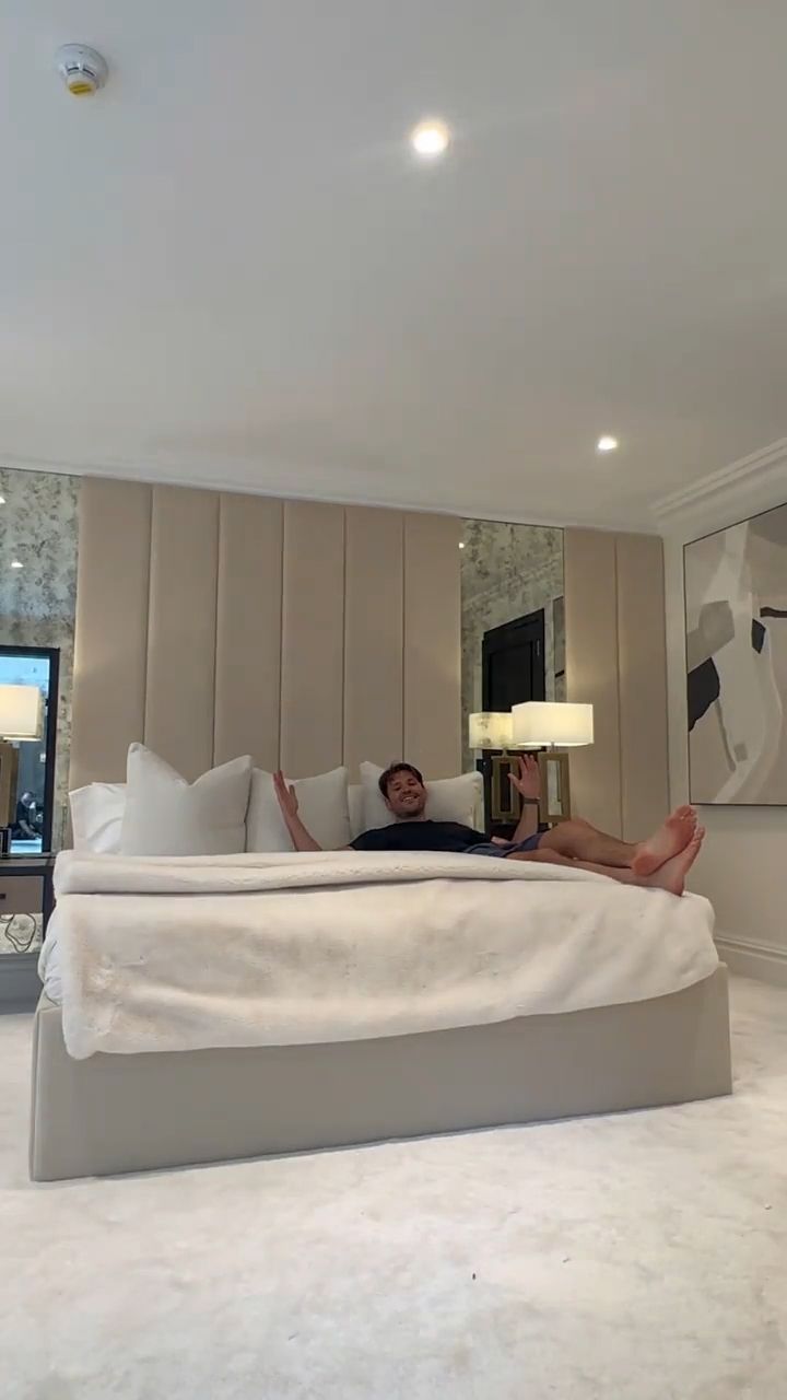 Mark Wright lying on his bed in a cream bedroom