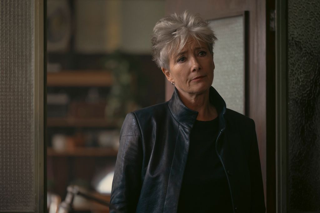 woman in black leather jacket standing in doorway