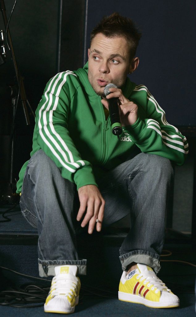 Brian Harvey singing in a green tracksuit and denim jeans