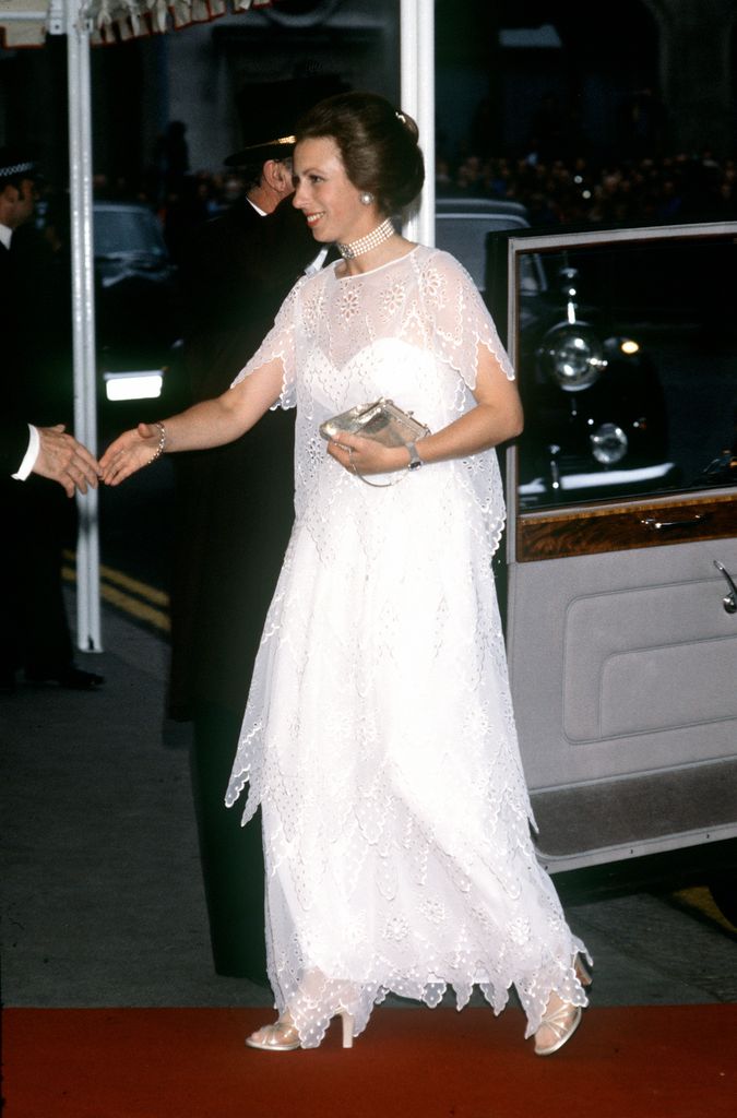 Princess Anne shaking person's hand on arrival in white dress