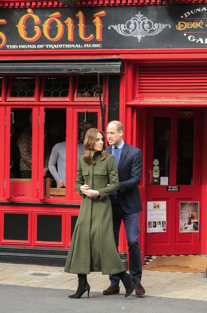 Kate in dark green coat with prince william outside irish pub