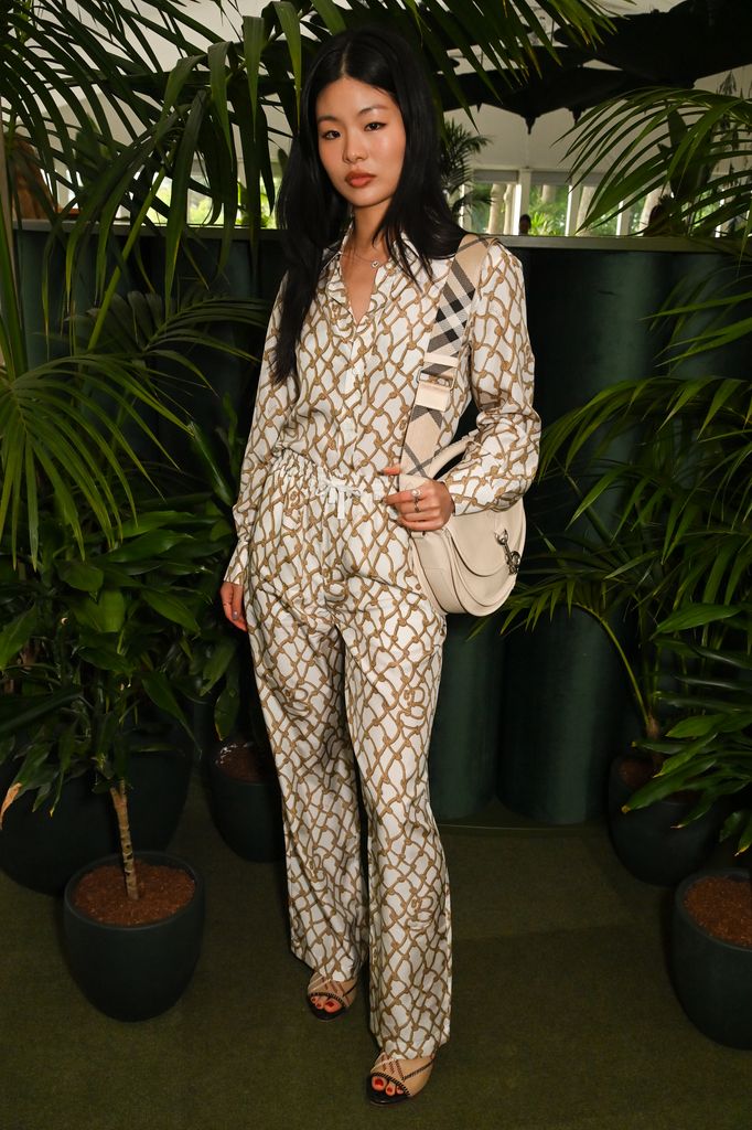 Yvonne Du in cream-and-gold rope-print shirt and matching trousers with crossbody bag and sandals at Chelsea Flower Show 2025 Burberry dinner.