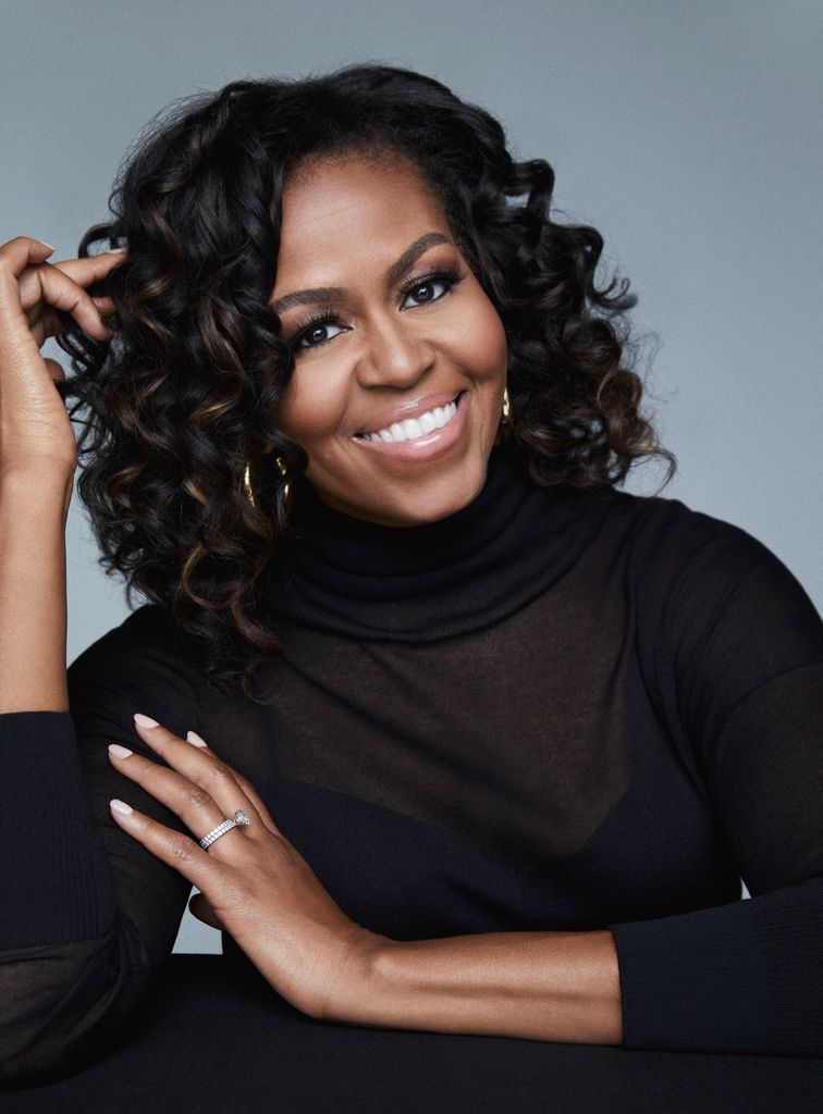 Michelle Obama in a black polo neck top smiling