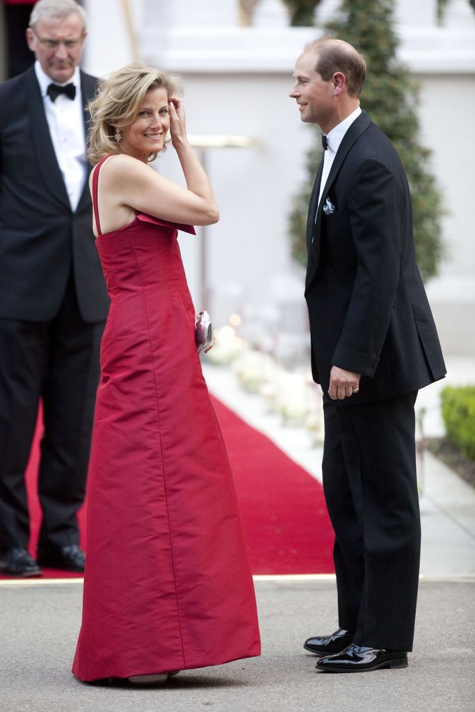 Prince Edward in a tuxedo with his wife Sophie in a red dress