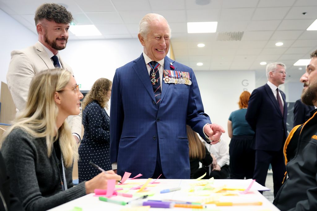 King Charles laughing with people sat at table