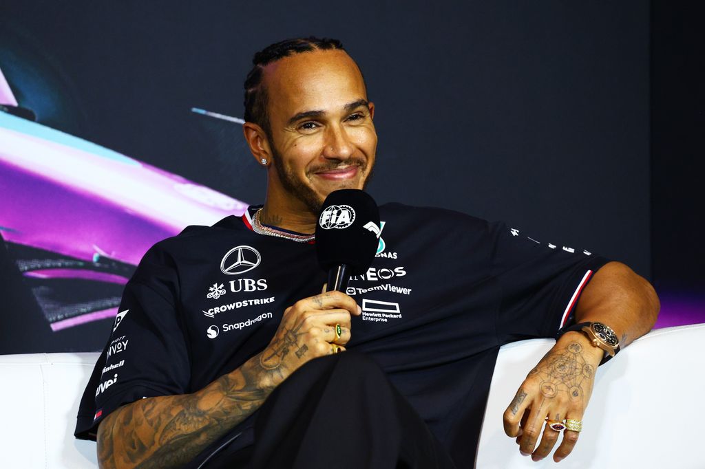 Lewis Hamilton holding a microphone in a black shirt