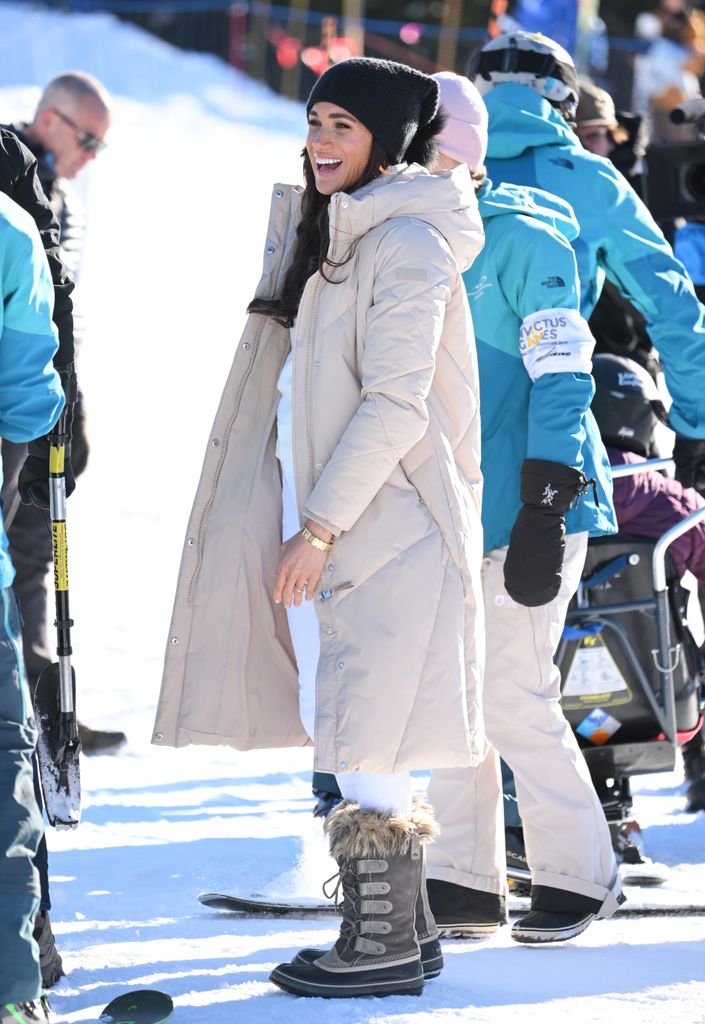Meghan Markle at the 2024 Invictus Games wearing a beige long puffer coat and brown hiking boots with fluffy trims