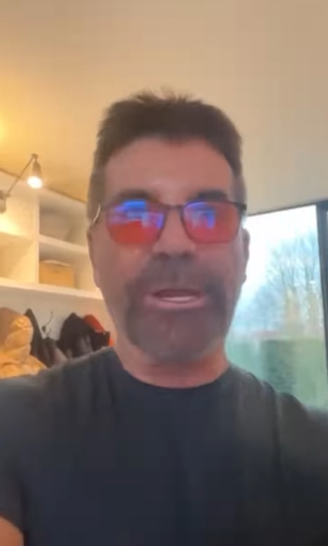 Simon Cowell takes a selfie video at home with his utility cupboard and garden seen in the background