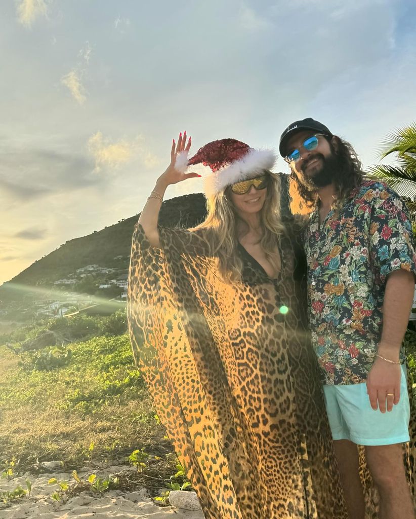 Heidi Klum in leopard print kaftan and santa hat on beach with tom kaulitz