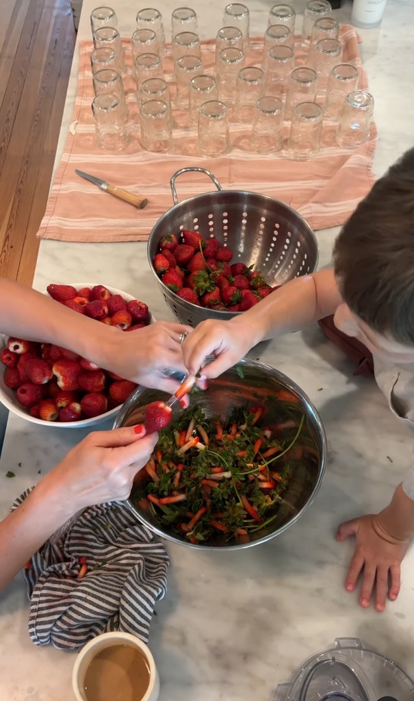Screenshot of a video posted by Joanna Gaines on Instagram June 2023 sharing a glimpse of hulling some strawberries to make jam with her son Crew