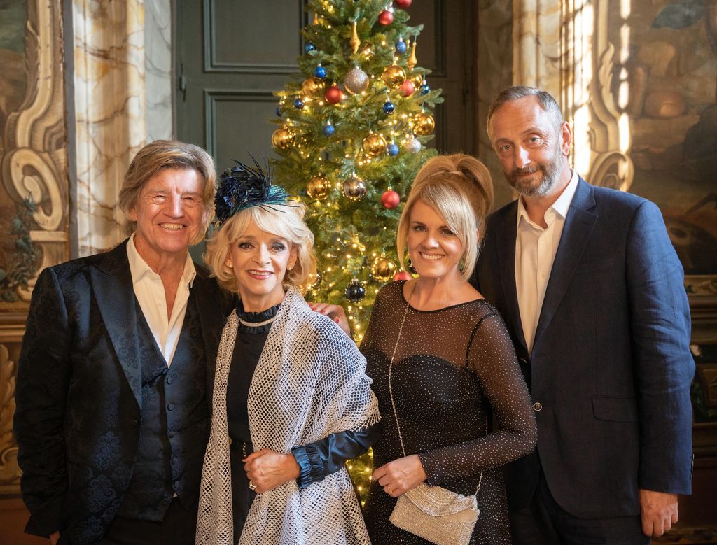 group of people smiling by christmas tree