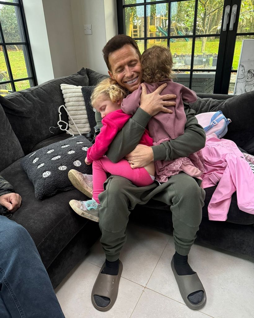 Joe's hugging his kids on sofa 