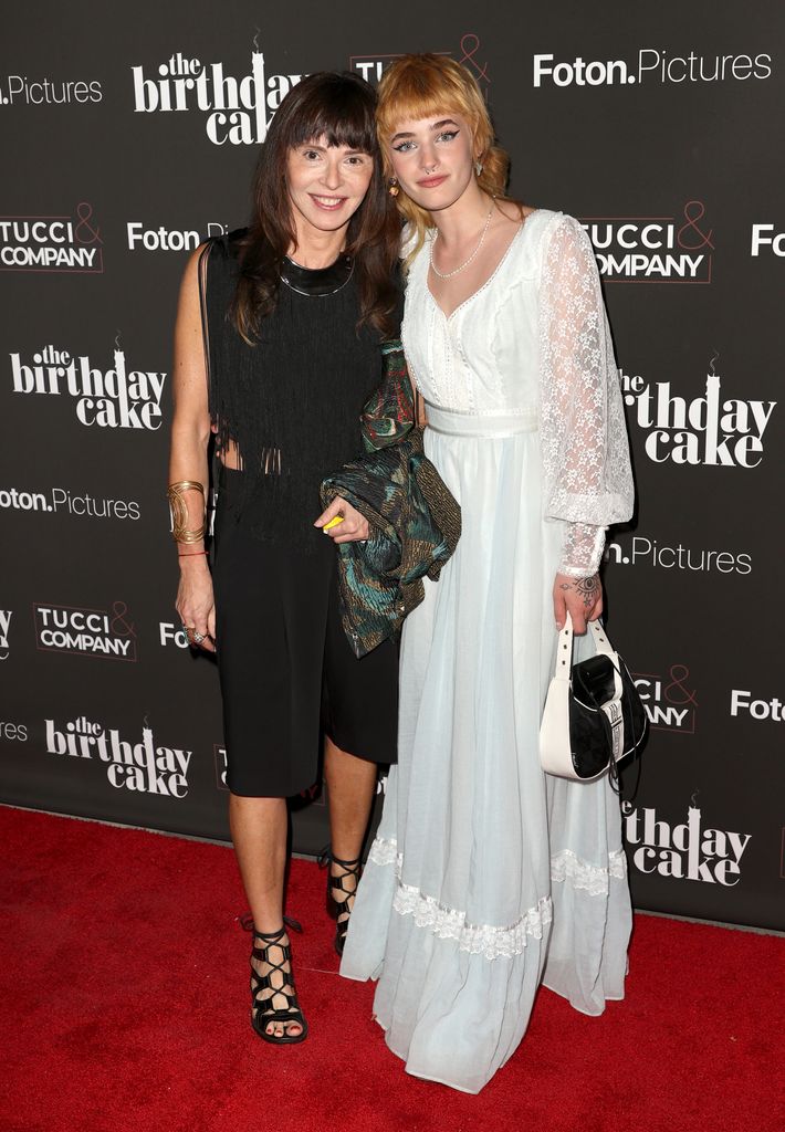 Eve Mavrakis in a black dress with her daughter Esther in a white dress