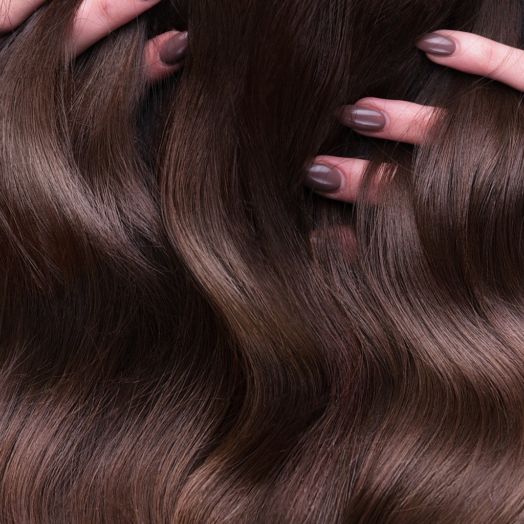 Manicured fingers running through hair