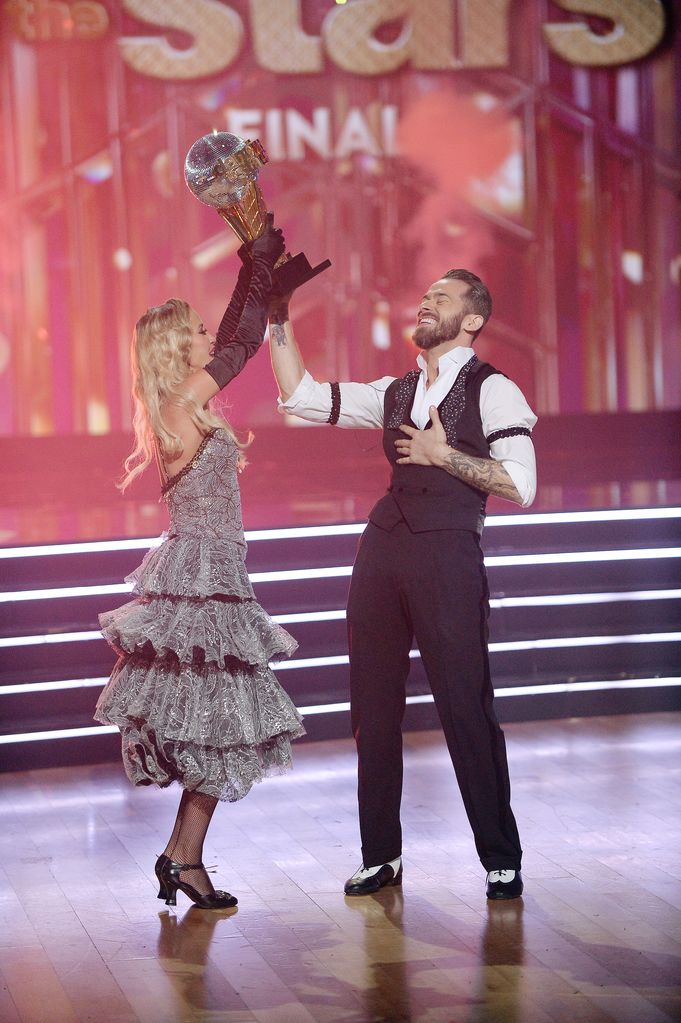 artem chigvintsev and kaitlyn bristowe lifting mirrorball trophy dwts 2020