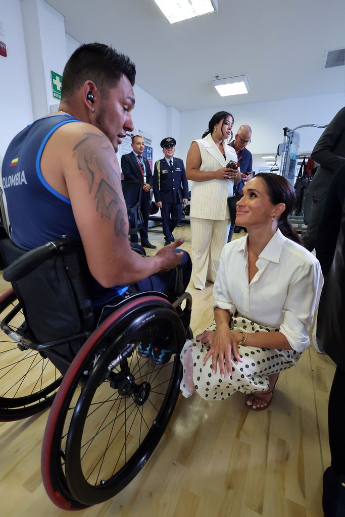 Meghan, Duchess of Sussex, speaks to a man in a wheelchair