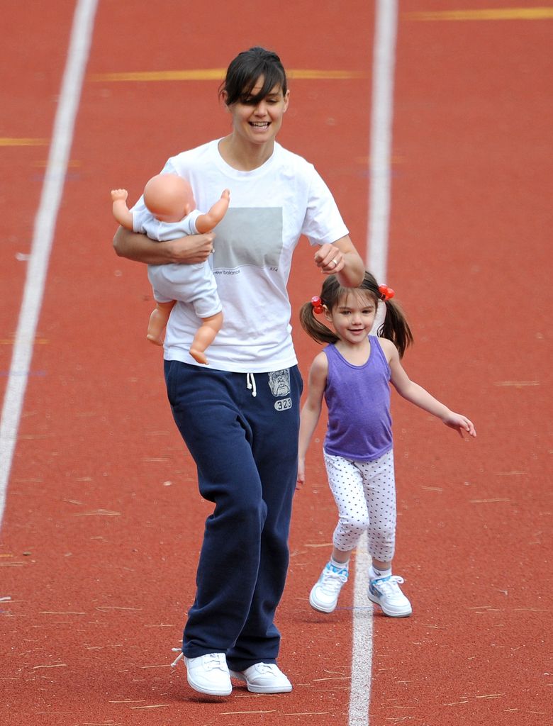 Katie Holmes and daughter Suri Cruise run track at a track field on October 12, 2009 in Boston, Massachusetts.